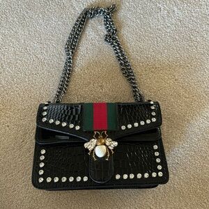 Black purse with bee at snap closure